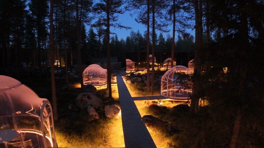 Private glass dinner dome lit from inside at dusk