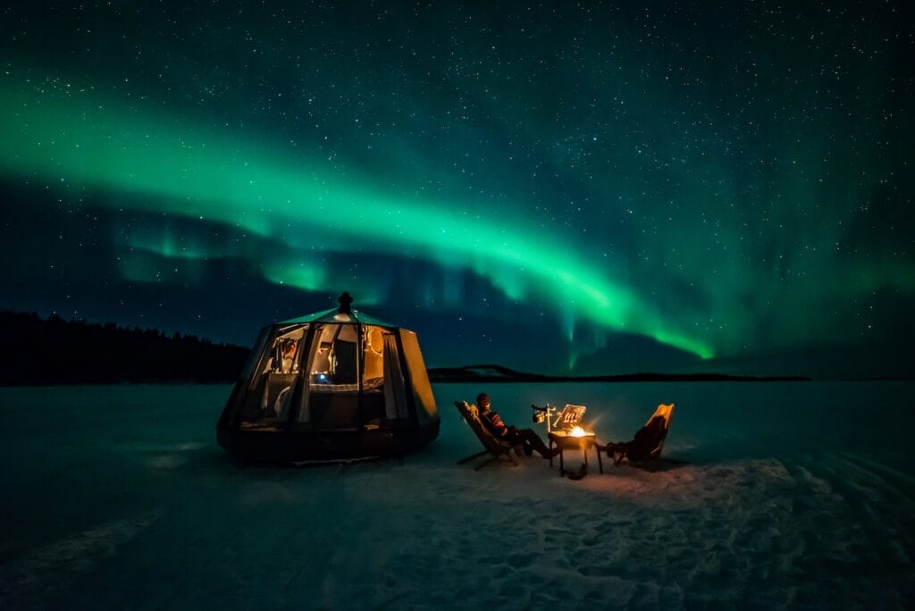 Aurora Hut glass cabin under the northern lights in winter
