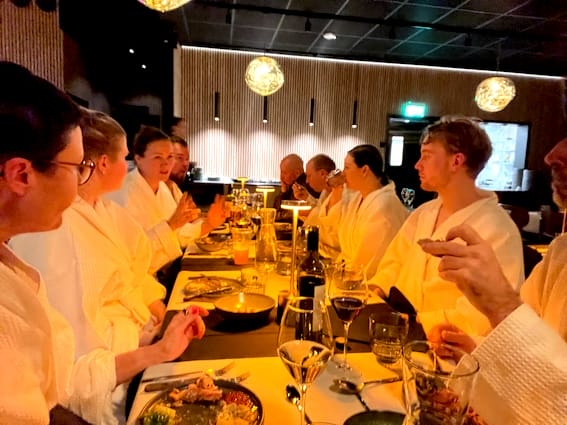 Guests dining in bathrobes at the long table
