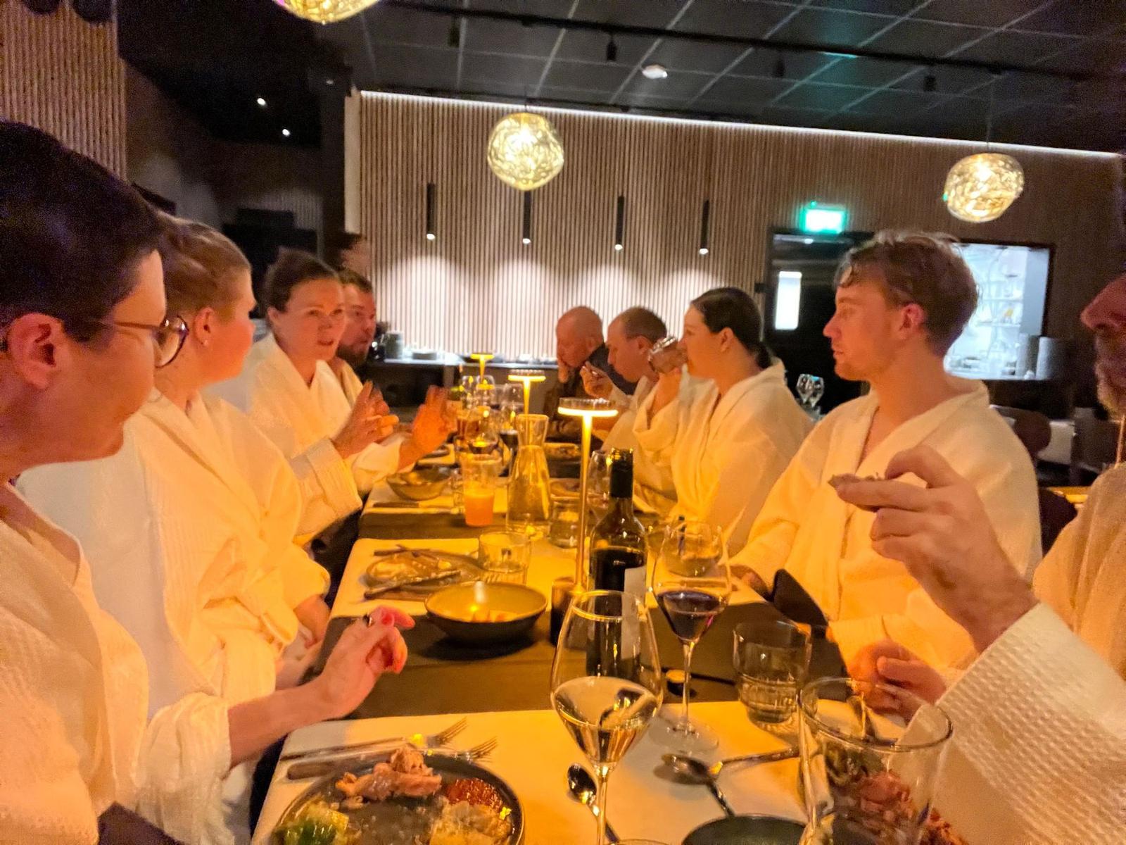 Guests dining together in bathrobes after the spa