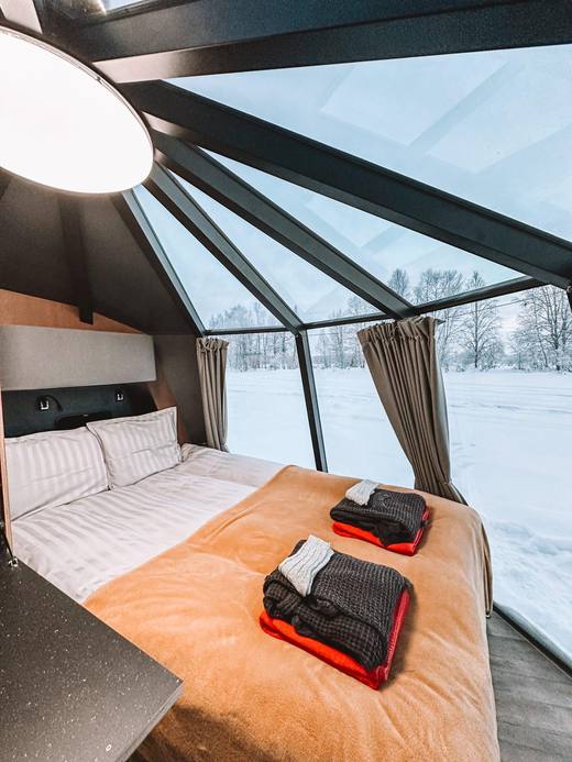 Bed under the glass dome with a river panorama