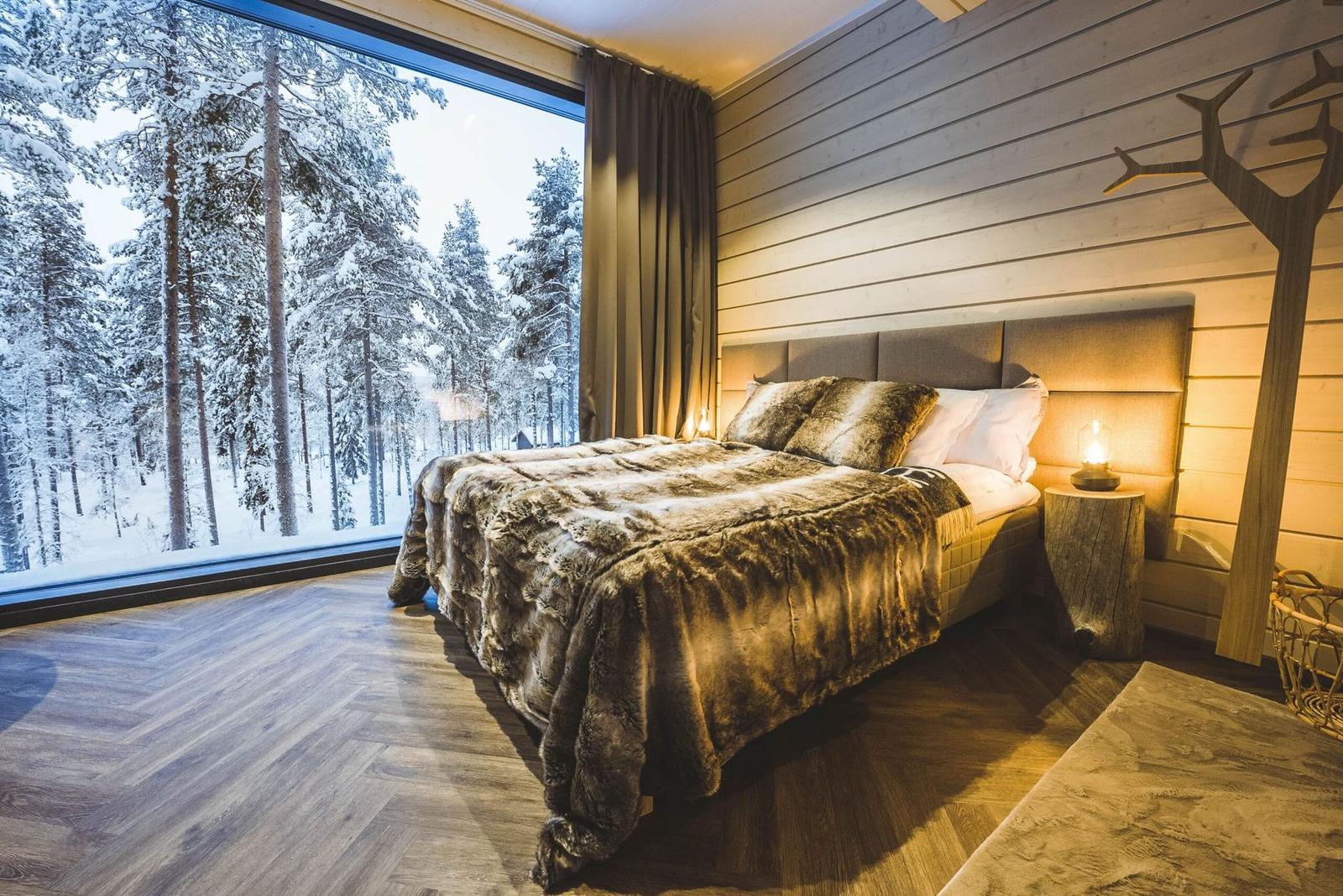 Bed facing the panoramic forest window